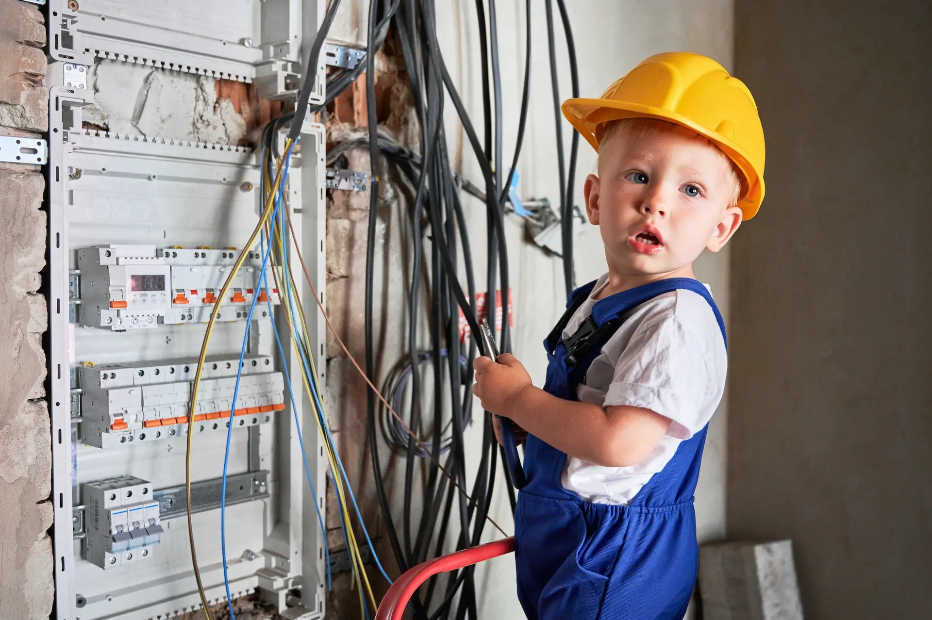 Little boy repairing electric cable in apartment under renovation.